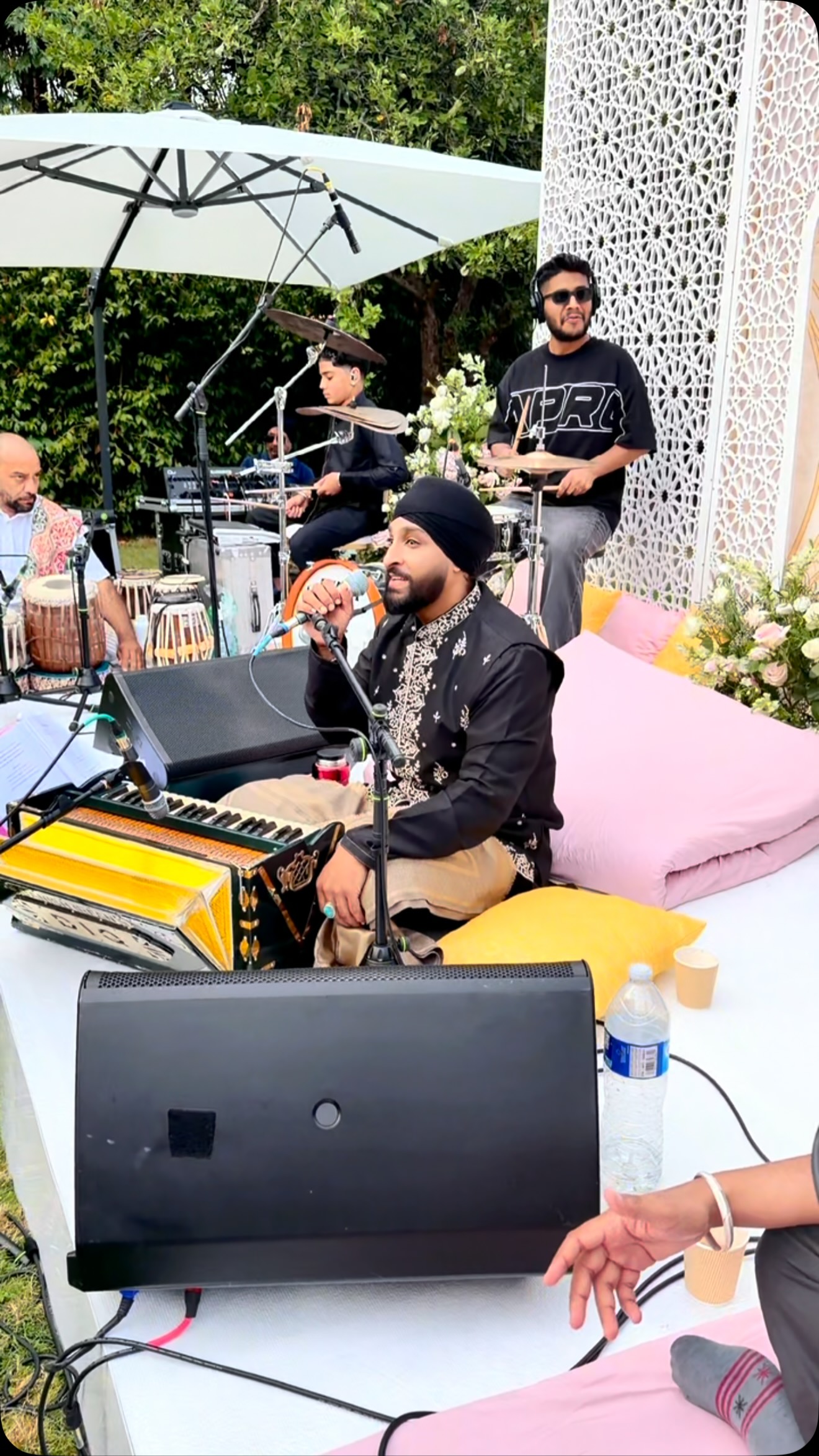 San2 singing with his band at an outdoor event
